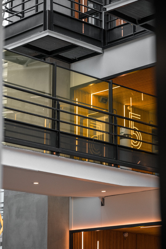 Balcony with glass panels behind a black metal bar railing (illustrative)